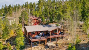 Une cabane dotée d’une terrasse, entourée d’arbres.