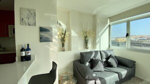 A modern living room with a grey sofa, two bottles of wine, and decorative vases on the wall. - On the beach with unbeatable views  (Telde)