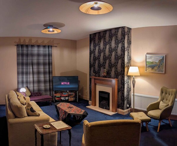 Älytelevisio, takka, kirjoja, videokirjasto