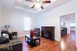 Cozy living space with a fireplace, sofa, and dining area.