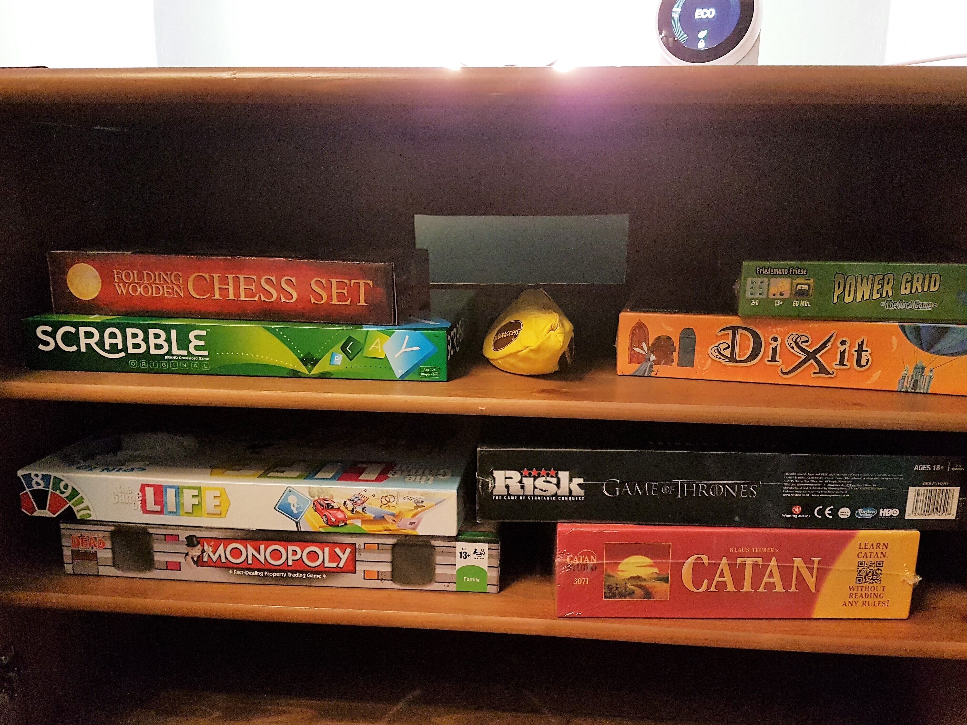 Hyllyssä on useita erilaisia lautapelejä, kuten Scrabble, Risk ja Monopoly.