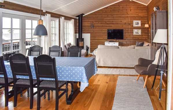 A cozy cabin-style room with a dining area, a sofa, and a TV. - Amazing home in øyer with kitchen (Øyer)