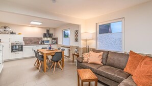 Un espacio habitable compacto con kitchenette, comedor y zona de estar.