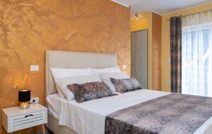 Une chambre à coucher avec un lit, une table de chevet et une lampe.