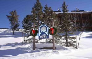 Un panneau indiquant la direction de Saint-Moritz, avec une chaîne de montagnes en arrière-plan.