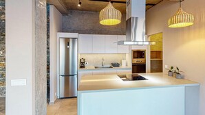 A modern kitchen with a central island, stainless steel appliances, and hanging wicker pendant lights. - Awesome home in Gazi, Heraklio (Gazi, Heraklio)