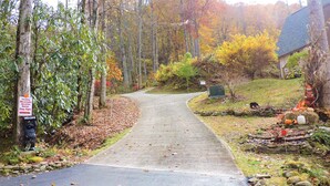 A pathway leading to a building surrounded by trees with autumn foliage. A 'Welcome' sign and a 'Keep Right' sign are visible. - Cozy cabin, Babbling Brook & Mountain View w/fast Wi-Fi (Robbinsville)