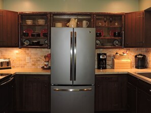 A stainless steel refrigerator with a double door, a coffee maker, and a toaster on a kitchen counter. - Cozy cabin, Babbling Brook & Mountain View w/fast Wi-Fi (Robbinsville)