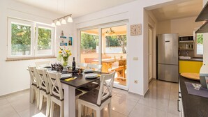 A modern kitchen with a dining area, large windows, and a built-in refrigerator. - Amazing home in Pula with WiFi (Pula)