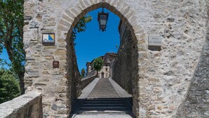 Arcada de pedra que dá acesso a uma escadaria em uma cidade histórica.