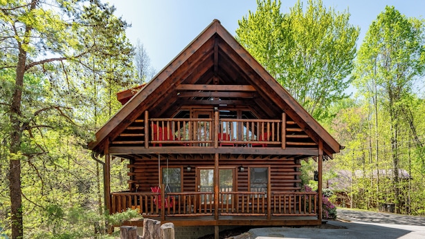 A two-story log cabin with a balcony and a porch, surrounded by trees. - Amazing Log Chalet, Scenic, Mountain View’s, Quiet (Sevierville)