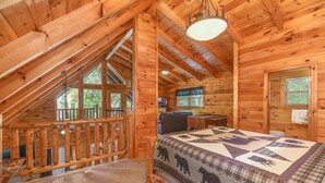 A cozy cabin with a loft bedroom, a dining area, and a view of the outdoors. - Amazing Log Chalet, Scenic, Mountain View’s, Quiet (Sevierville)