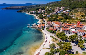 An aerial view of a coastal town with a beach, clear blue waters, and a mix of residential buildings. - 4 bedroom stunning home in Slano (Slano)