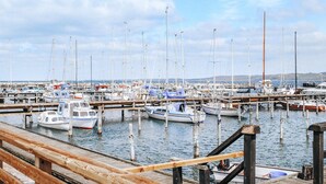 Un port de plaisance où de nombreux bateaux sont amarrés à des quais en bois.