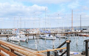 Boats dock at the marina, surrounded by water and a hilly landscape.