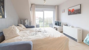 Een moderne slaapkamer met een groot bed, een televisie en een radiator.