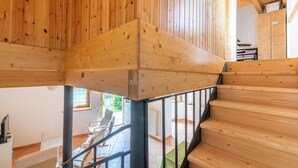 A wooden staircase with metal railings leading to a lower level.