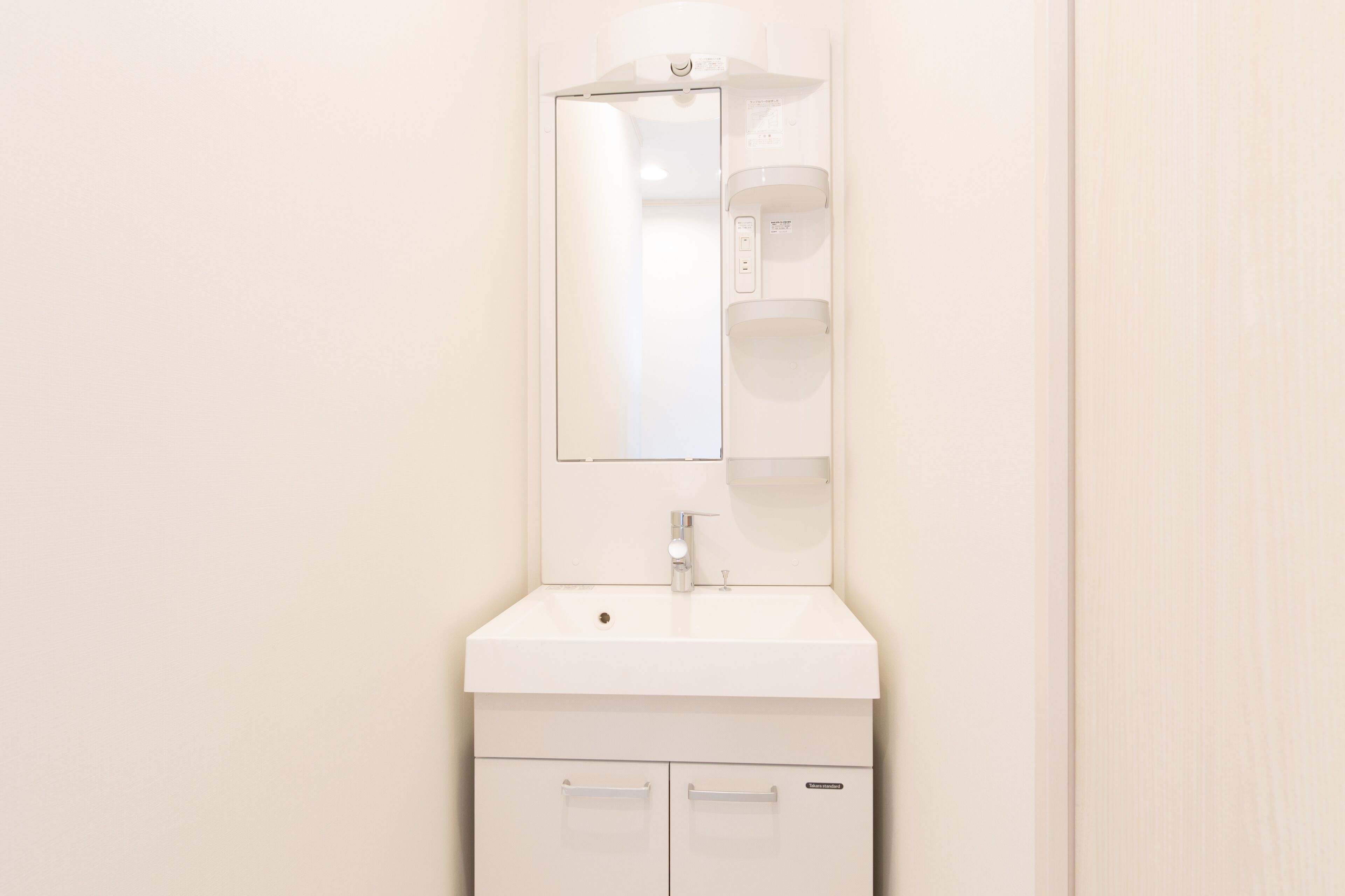 A white bathroom vanity with a mirror, sink, and two drawers.
