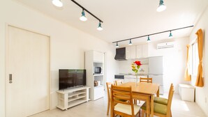 A compact living space with a dining area, kitchenette, and a TV. - Regina Ishigaki Blue Stage (Ishigaki)