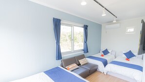 Una habitación de hotel con dos camas, un sofá y una ventana con cortinas.
