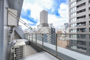 Guests can enjoy a balcony with a railing overlooking the city.
