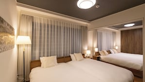Ett hotellrum med två sängar, en stor spegel och en golvlampa.