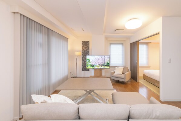 Relax in a spacious living area with a large flat-screen TV and comfortable sofa.