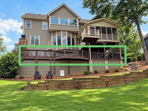 A two-story house with a deck, a balcony, and a front yard. - 2 King Beds, Outdoor Fireplace and Air Hockey (Canton)