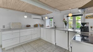 A modern kitchen with white cabinets, a granite countertop, and a wooden ceiling. - Gorgeous home in Højer with WiFi (Højer)