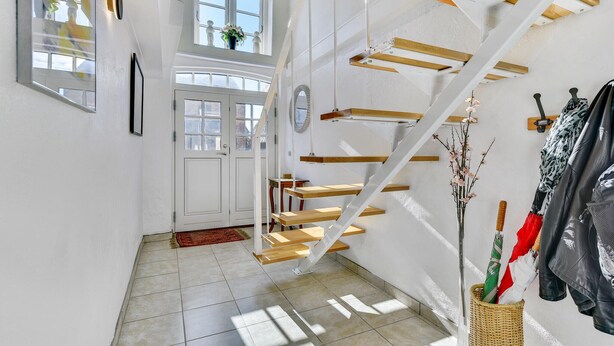 A modern interior with a staircase, white walls, and a door with glass panels. - Gorgeous home in Højer with WiFi (Højer)