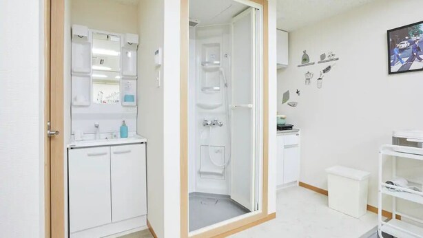 Uma casa de banho moderna com chuveiro, sanita e lavatório.