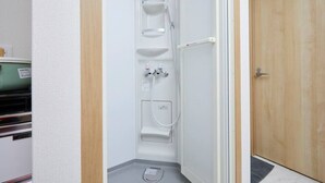 A small, enclosed shower area with a built-in sink and a step stool. - TORA HOTEL Taito B (Tokyo)