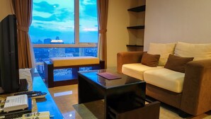 A modern living room with a sofa, a coffee table, and a TV. - Fantastic View 2BR Apartment at FX Residence Sudirman (Jakarta)