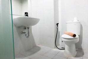 A bathroom with a white sink, toilet, and shower. - Nice and Prime Location 1BR Casa De Parco Apartment (Pagedangan)