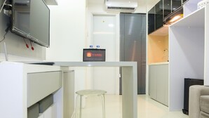 A modern kitchen with a built-in stove, a small bar area, and a seating space with stools.