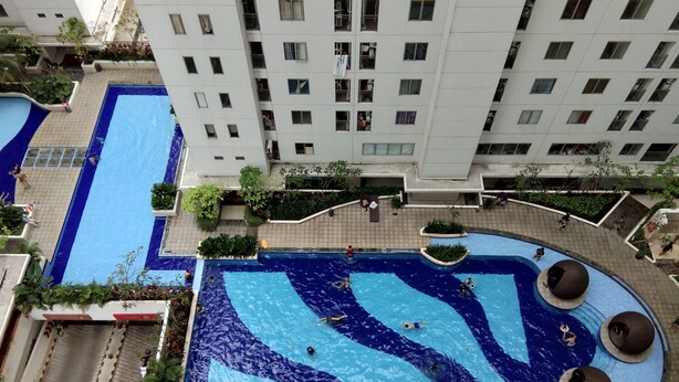 A rooftop swimming pool with multiple lanes and a circular area with seating.