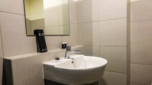 A bathroom with a white sink, a mirror, and a toothbrush holder. - Brand New Studio Room at Bintaro Icon Apartment (South Tangerang)