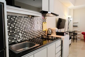 Room | Private kitchenette | Fridge, stovetop, cookware/dishes/utensils - Homey and Simply Studio at Paramount Skyline Apartment (Gading Serpong)