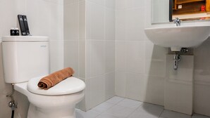Une salle de bain avec des toilettes, un lavabo et un miroir.