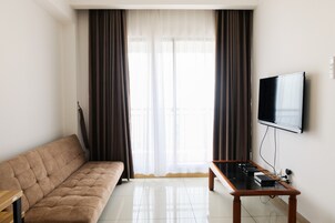 Una sala de estar moderna con un sofá, una mesa de centro y un televisor de pantalla plana montado en la pared.