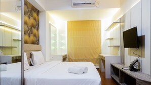 A hotel room with a bed, bedside tables, a TV, and a large window. - Premium 1BR Apartement At Grand Sungkono Lagoon (Surabaya)