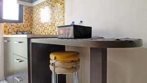 A kitchen with a tiled backsplash, a countertop, a sink, and a stool. - Best Deal Studio at Kebagusan City Apartment (Jakarta)