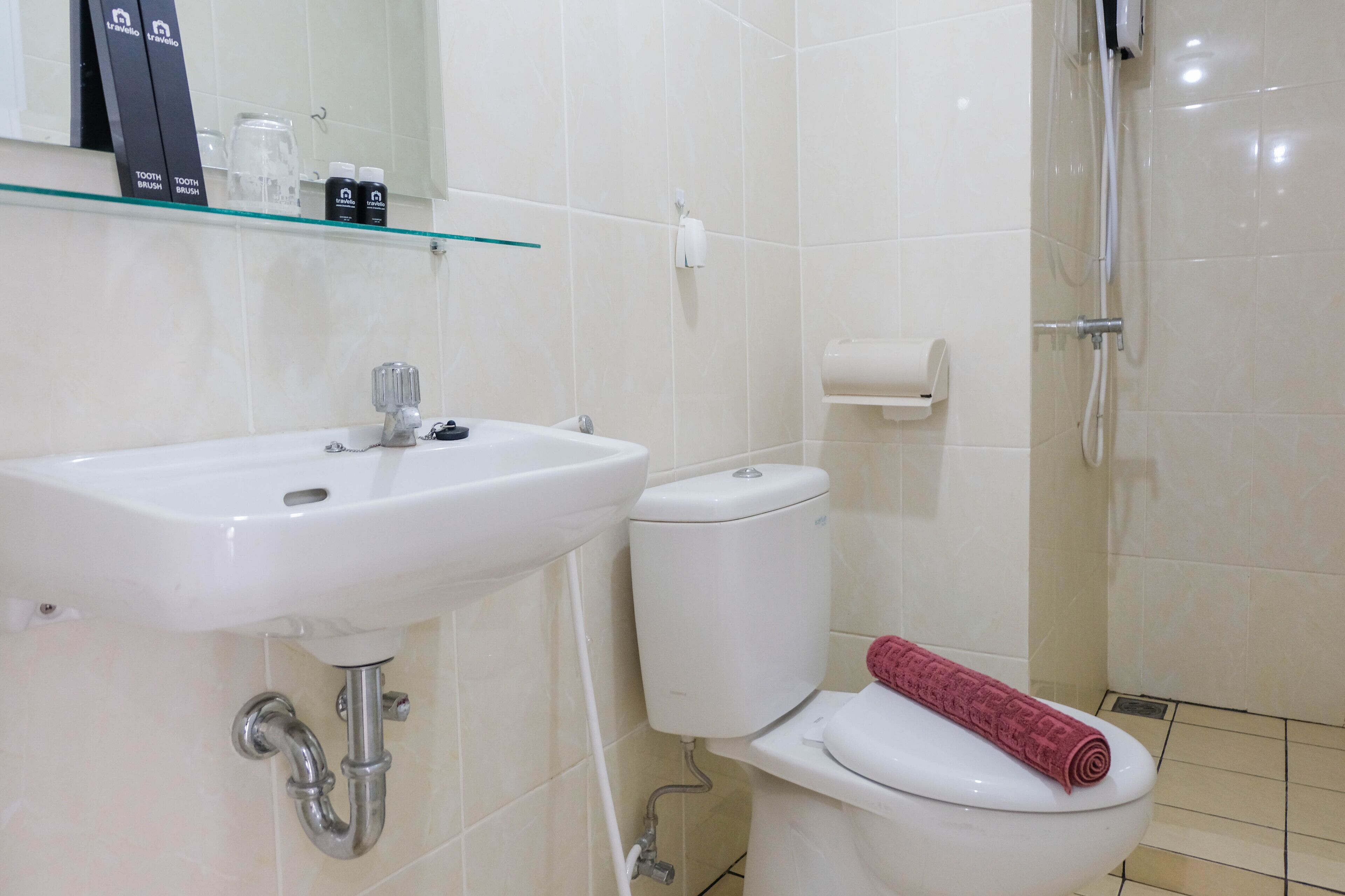 A bathroom with a white sink, toilet, and glass shower enclosure.