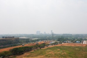 Une vue d’ensemble d’une ville, avec une vaste place ouverte, quelques bâtiments et une ligne d’horizon lointaine.