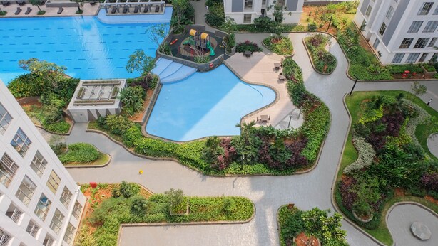 A rooftop pool surrounded by lush greenery and modern buildings. - Comfortable 2BR Apartment Serpong M-Town Residence (Gading Serpong)