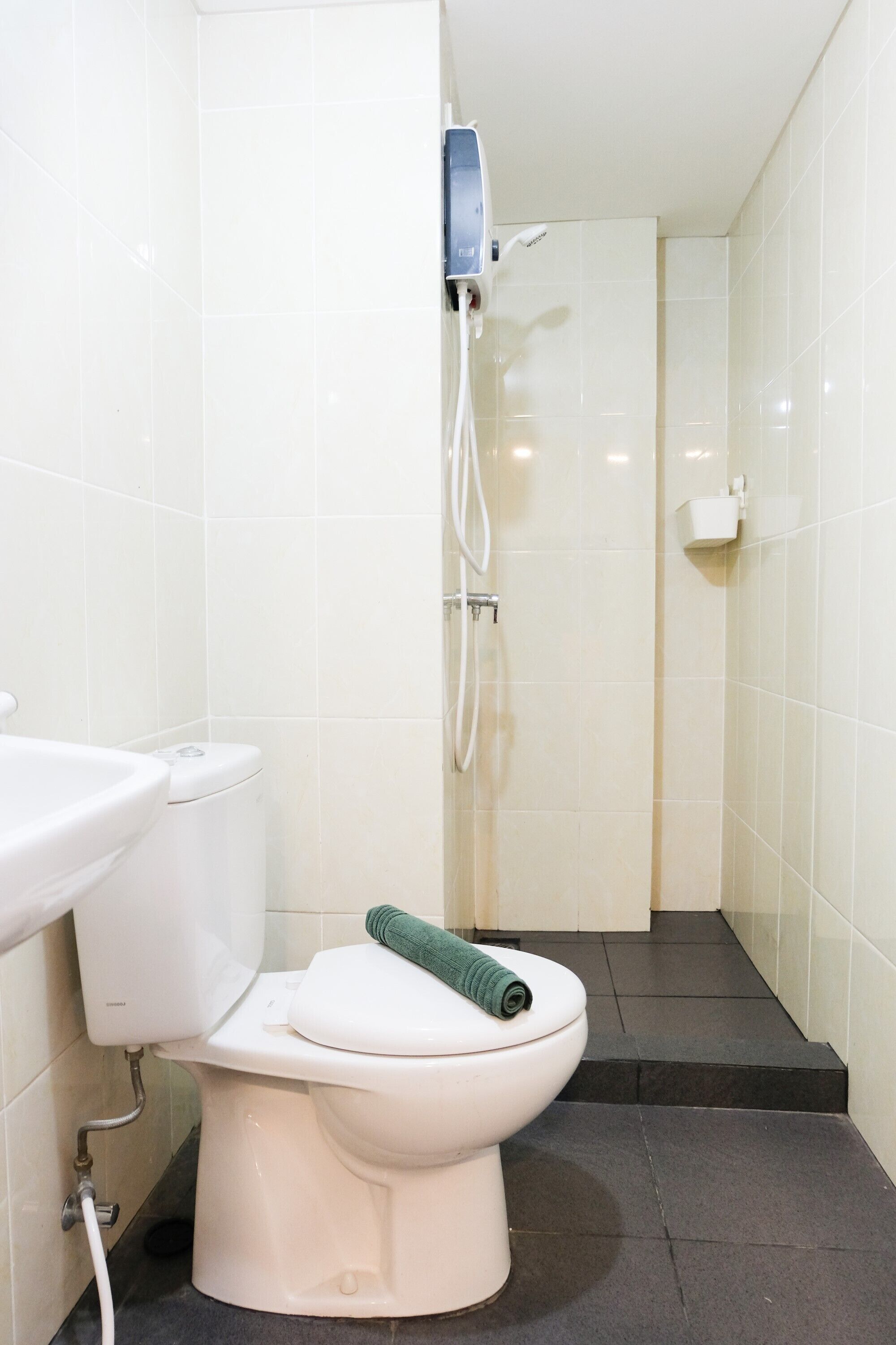Een badkamer met toilet, wastafel en douche.