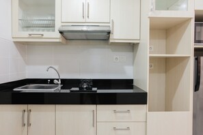 Room | Private kitchenette | Fridge, microwave, stovetop, cookware/dishes/utensils - Cozy with City View Studio at Scientia Apartment (Gading Serpong)