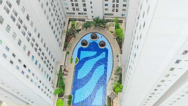 Ein Hochhaus mit einem zentralen Schwimmbecken im Wellen-Design.