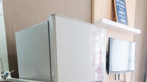 Une cuisine équipée d’un réfrigérateur à deux portes, d’un évier encastré et d’un plan de travail en bois.