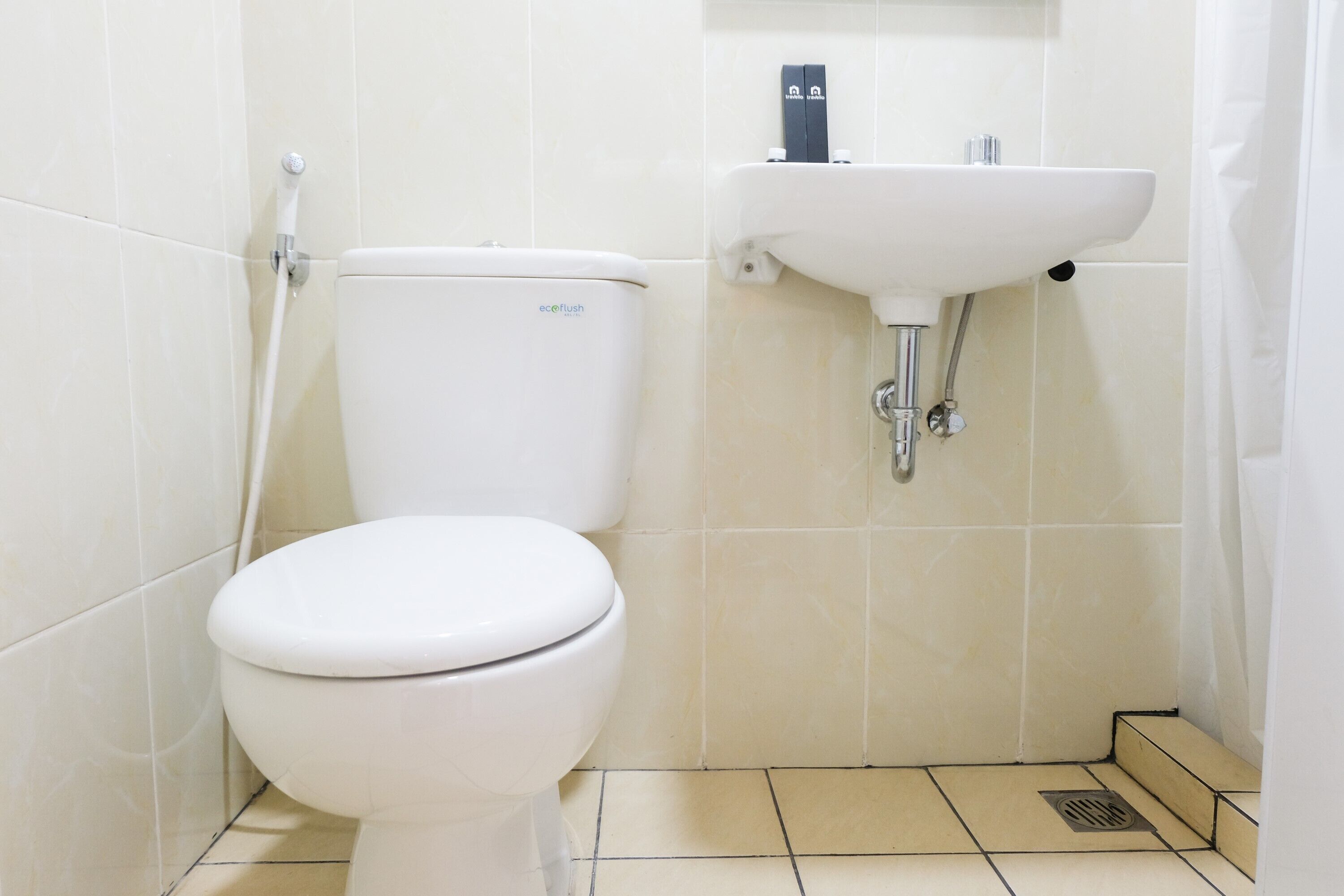 A small, clean bathroom with a white toilet, a sink, and a shower.